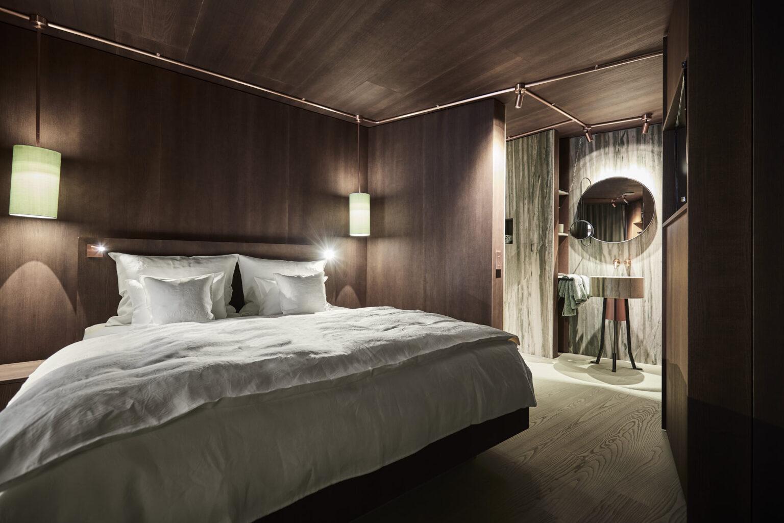 Parterre Zimmer im Boutique Hotel Badhaus mit italienischen Leinen, Holzboden und Zugang zur Terasse, Blick auf den Sanitärbereich.